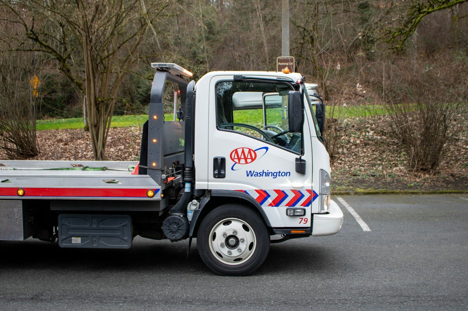 A white tow truck is parked on the street